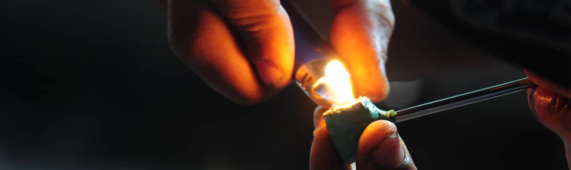 Crack Cocaine Addiction and Abuse Pathfinders - Close up photo of someones hands as they hold a crack pipe in one hand and light a lighter to smoke crack with the other. Crack Cocaine Addiction and Abuse is a dangerous problem here in the U.S.
