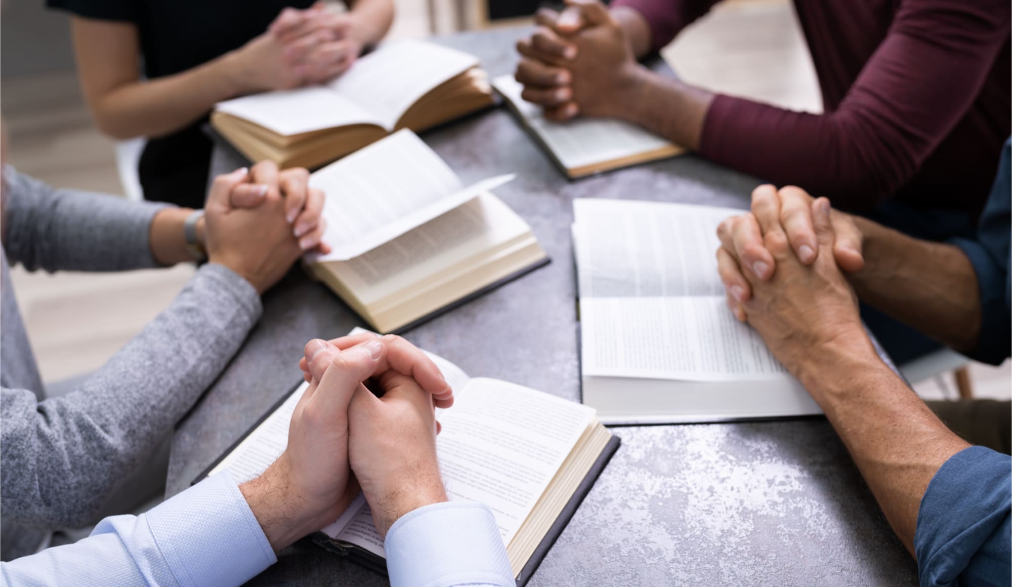 Faith-Based Addiction Treatment Pathfinders - The hands of a group of people who are in prayer during their faith based addiction treatment.