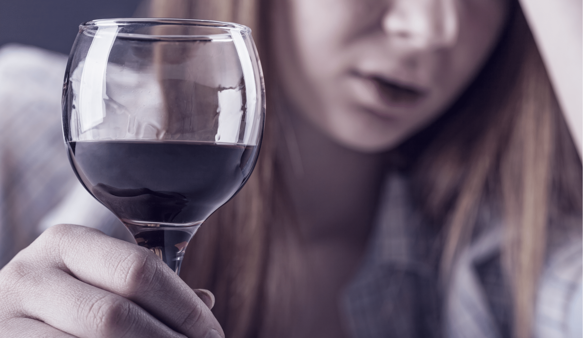 How Can You Get Sober from Alcohol? - Pathfinders Recovery Center - A woman is questioning, "How can you get sober from alcohol?" as she sits at her counter with another glass of wine.