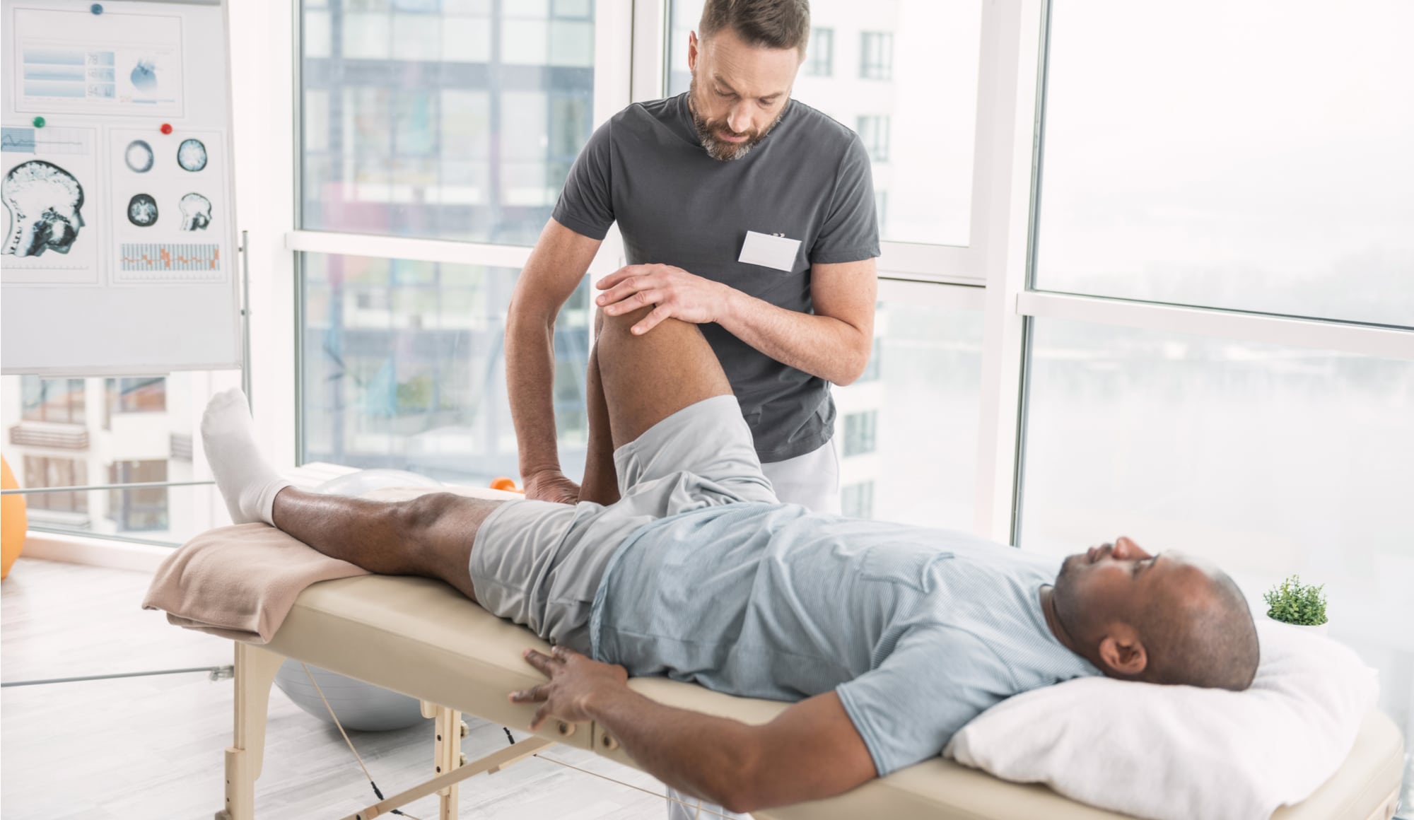 Opioid Alternatives: How to Find Pain Medications That Aren't Addictive Pathfinders - A middle-aged man is engaging in physical therapy with a professional physical therapist as one of the available opioid alternatives to manage pain and improve the healing process instead of abusing opioid medications.