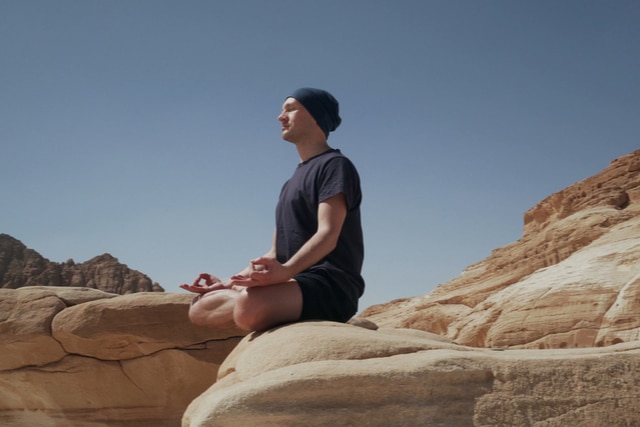 Sober Life - A man living the sober life does yoga in the desert. Since he has become sober he takes care of himself and enjoys the things around him.